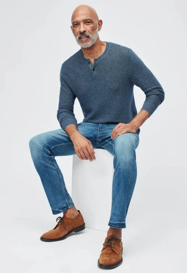 A grey jumper, brown suede shoes, and  light blue jeans